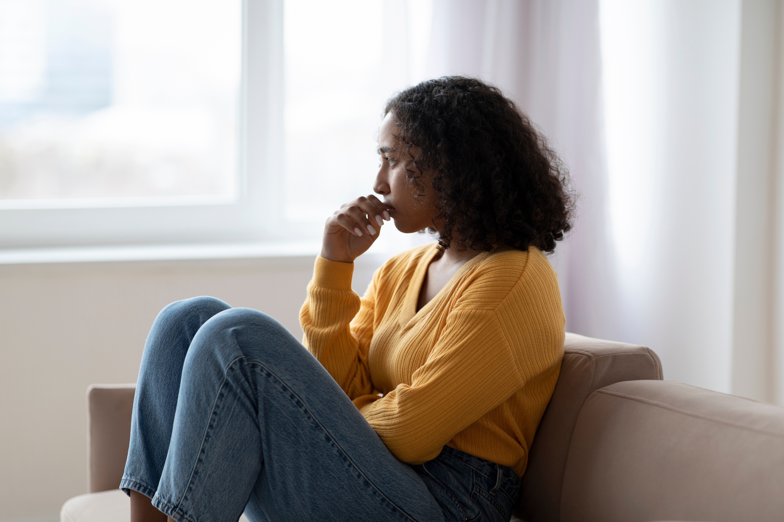 woman sitting on the couch struggling with what does depression feel like