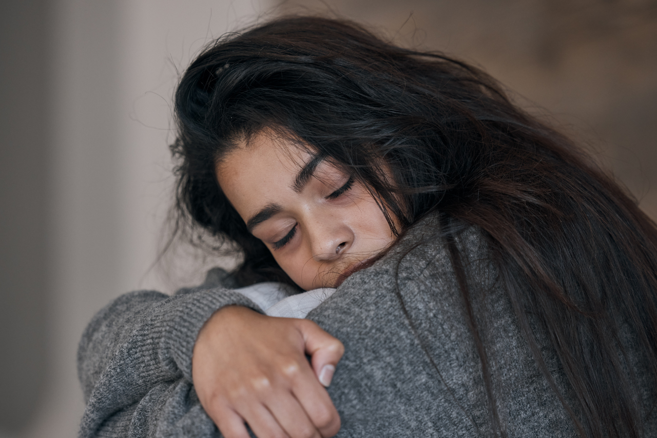 woman holding on to herself struggling with how a person with bipolar thinks