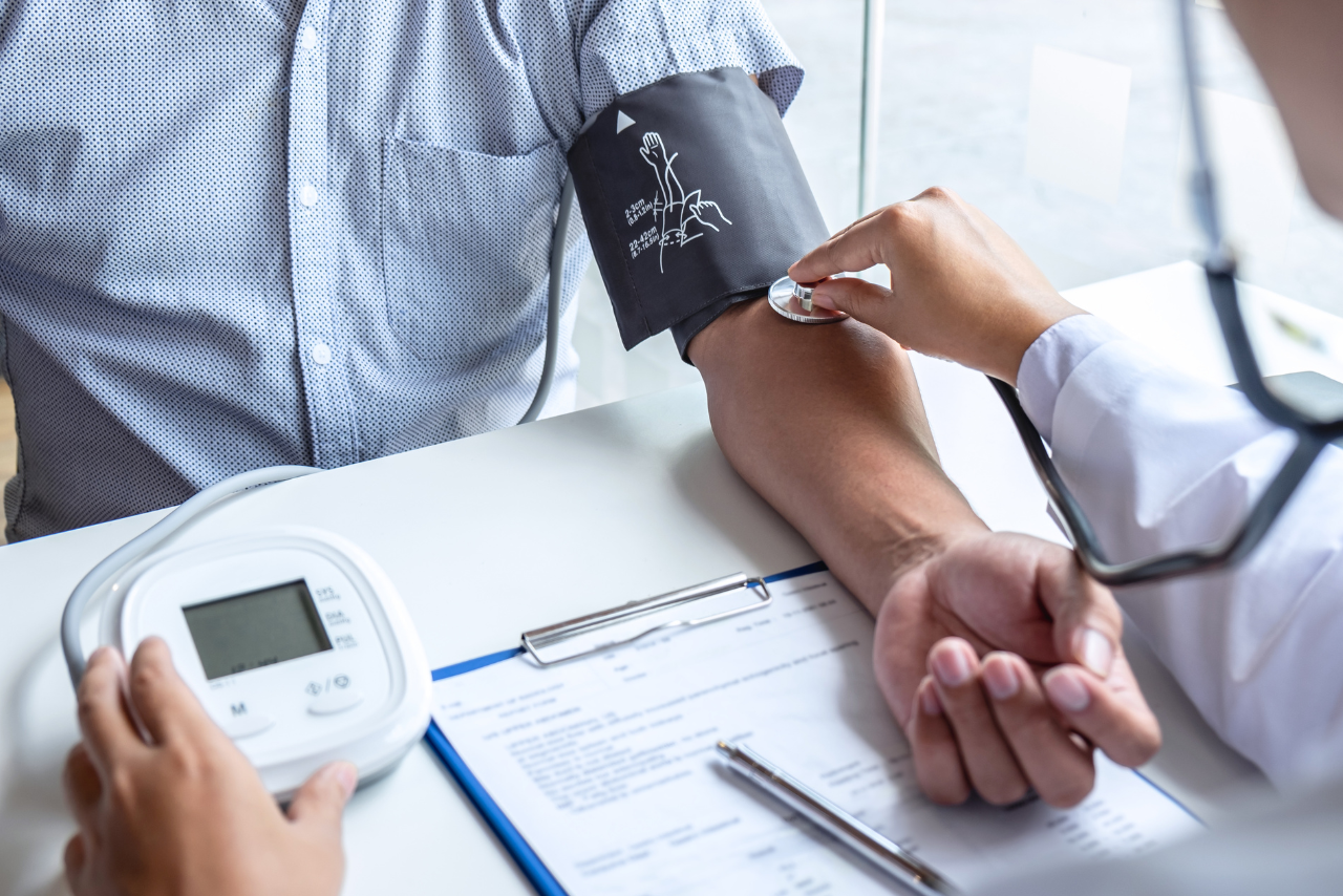 nurse taking a patients blood pressure while he is asking Can Anxiety Cause High Blood Pressure?