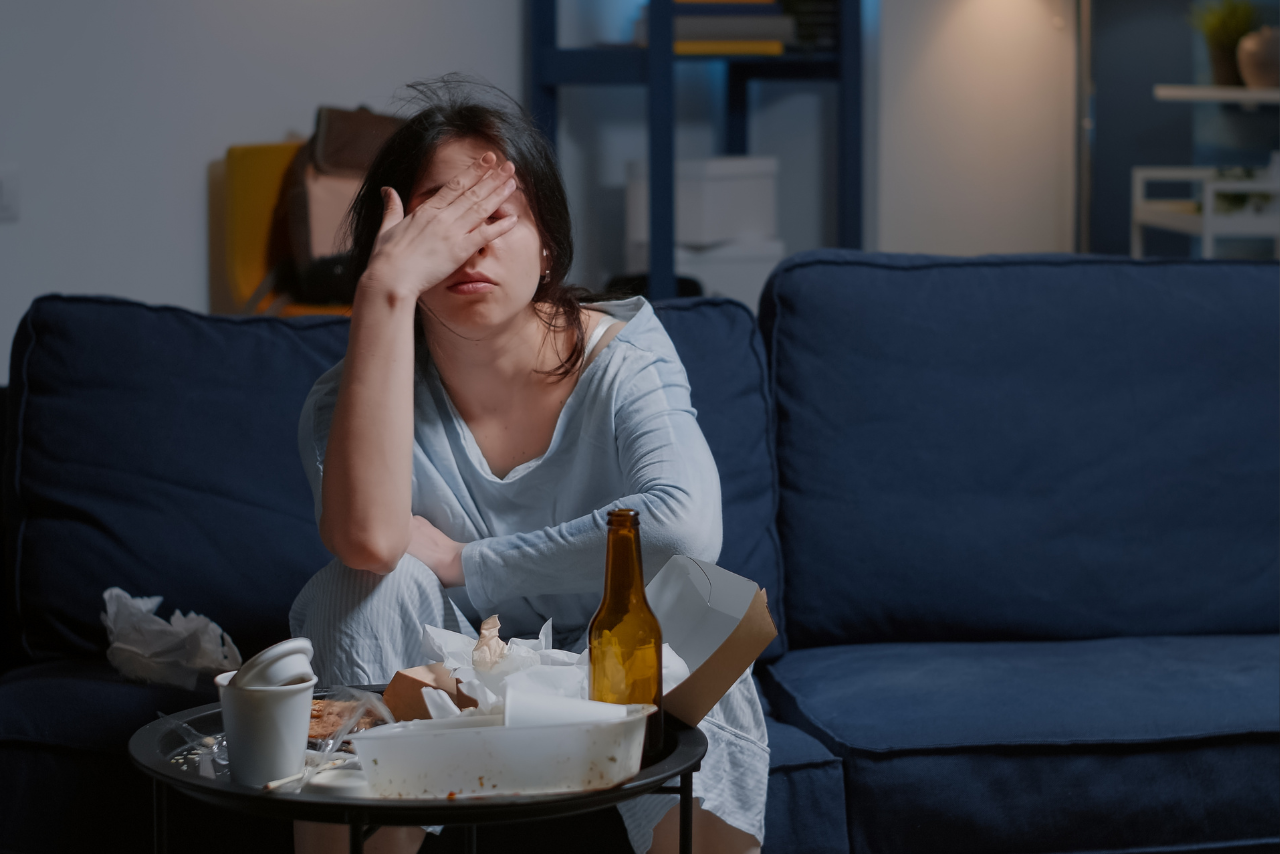 woman surrounded by trash sitting on the couch struggling wondering can depression cause memory loss