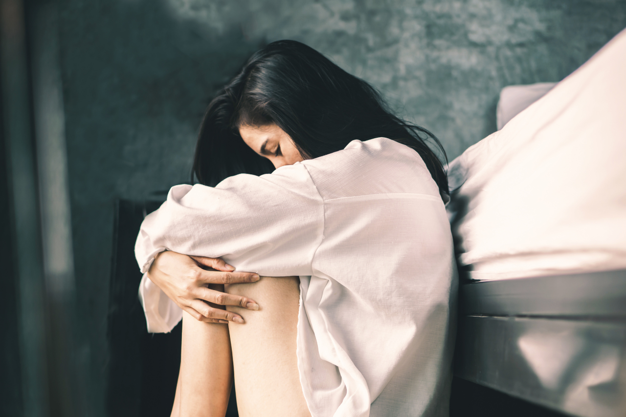 woman sitting on the floor struggling with her mental health due to a self harm addiction