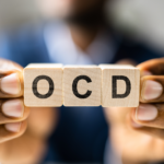 man holding up blocks spelling out OCD