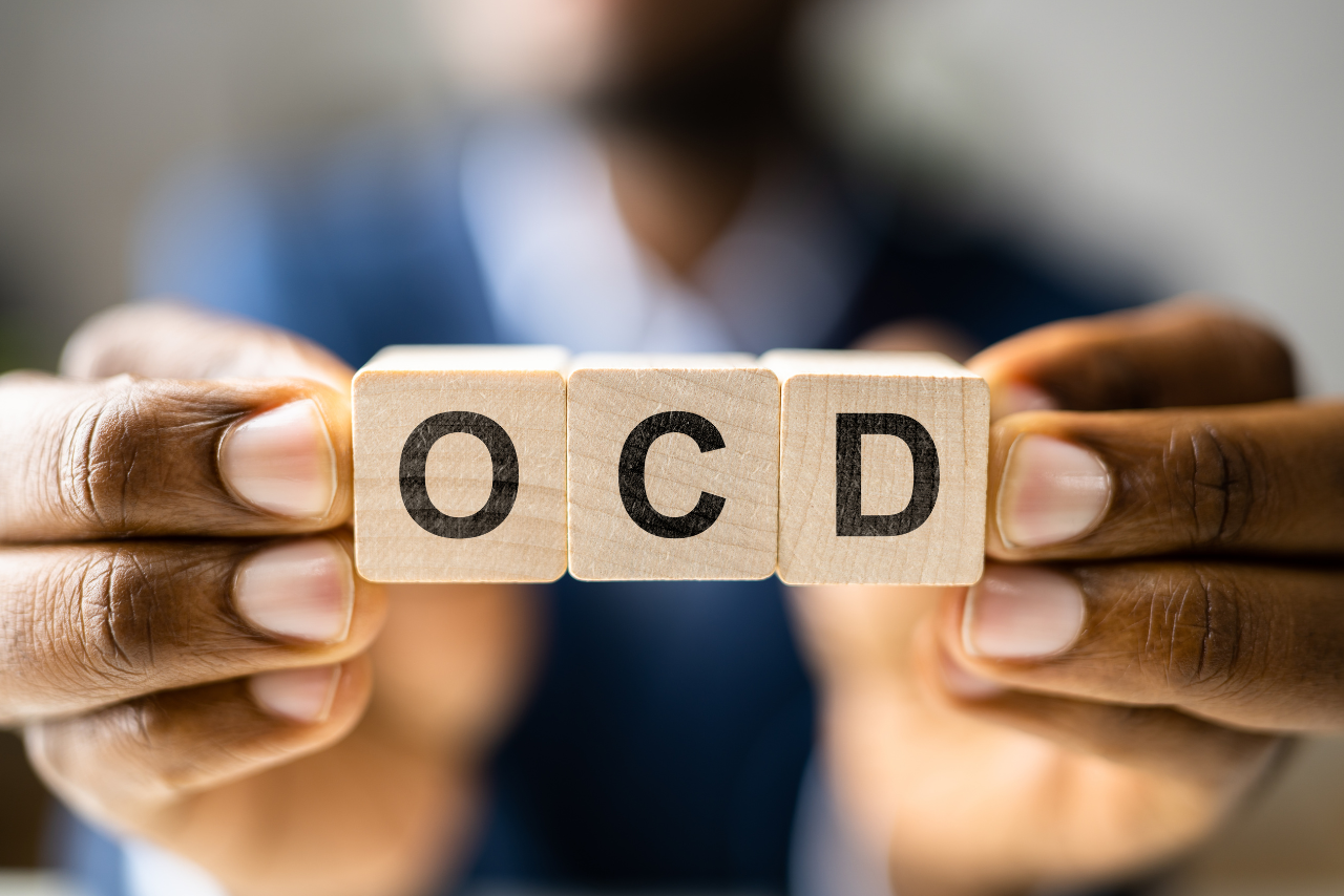 man holding up blocks spelling out OCD